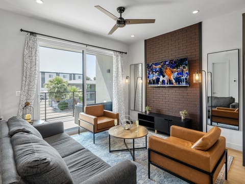 1st Floor: Warm and inviting living room featuring a Smart TV for entertainment, and designer furnishings including a sleeper sofa that converts into a Queen Bed.