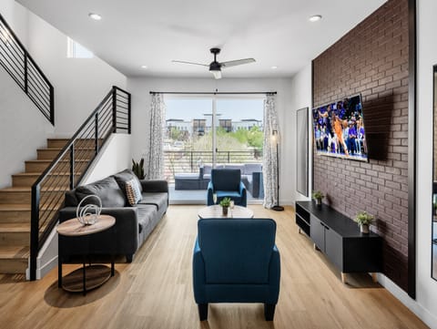 1st Floor: Warm and inviting living room featuring a Smart TV for entertainment, and designer furnishings including a sleeper sofa that converts into a Queen Bed.