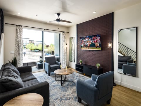 1st Floor: Warm and inviting living room featuring a Smart TV for entertainment, and designer furnishings including a sleeper sofa that converts into a Queen Bed.