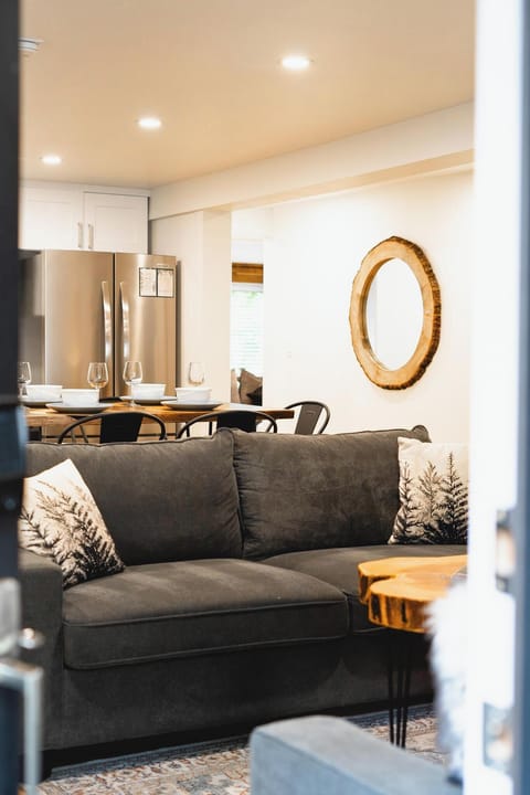 - Cozy living space with plush sofa and stylish accents  
- Open layout connects seating to kitchen and dining area  
- Relax in comfort with modern decor and warm details  