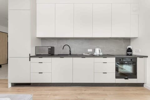 A modern kitchen in white and grey offers full equipment, encouraging you to prepare meals in an elegant setting.