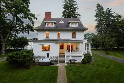 Step into history with the beautifully restored Pearson House, glowing under the evening sky. A timeless retreat along the Owasco River.