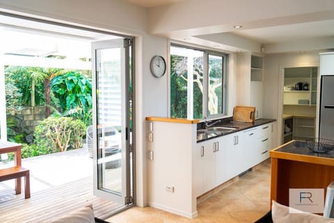 Open plan, fully equipped modern kitchen leading to private sunny outdoor area