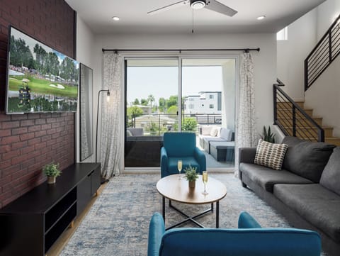 Unit 1 (1st Floor): Warm and inviting living room featuring a Smart TV for entertainment, and designer furnishings including a sleeper sofa that converts into a Queen Bed.