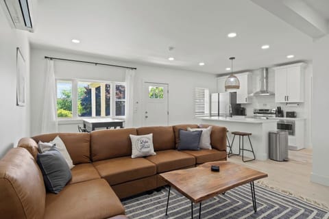 Experience ultimate comfort in this spacious living room, perfect for relaxing after a day exploring Sodus Point. The modern design features a plush leather sectional, a sleek coffee table, and a cozy rug, creating an inviting atmosphere. Enjoy movie