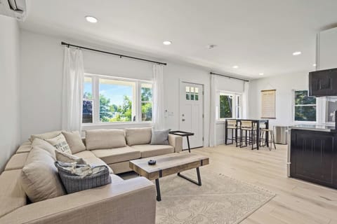 Bask in the natural light that floods this elegant living area. The spacious sectional sofa and minimalist décor provide a tranquil setting for relaxation. With large windows and a serene color palette, this living room offers a perfect retreat for u