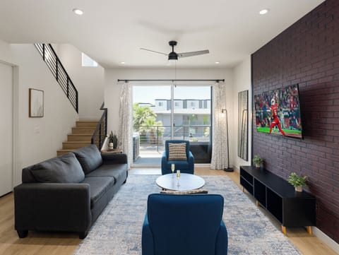 Unit 1 (1st Floor): Warm and inviting living room featuring a Smart TV for entertainment, and designer furnishings including a sleeper sofa that converts into a Queen Bed.