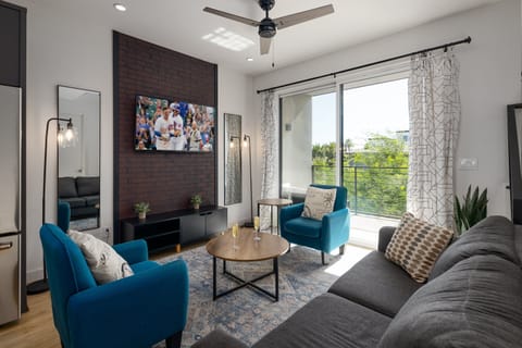 Unit 1 - 1st Floor: Warm and inviting living room featuring a Smart TV for entertainment, and designer furnishings including a sleeper sofa that converts into a Queen Bed.