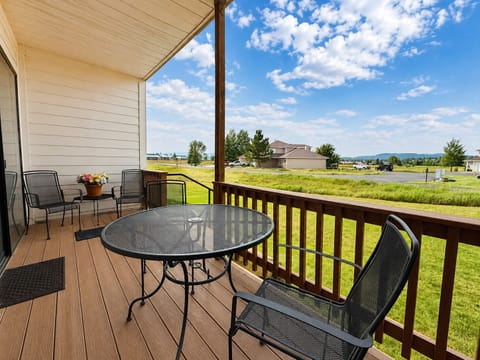 Relax on your private covered deck with seating for morning coffee or evening sunsets, overlooking peaceful green meadows and mountains beyond under wide open skies.
