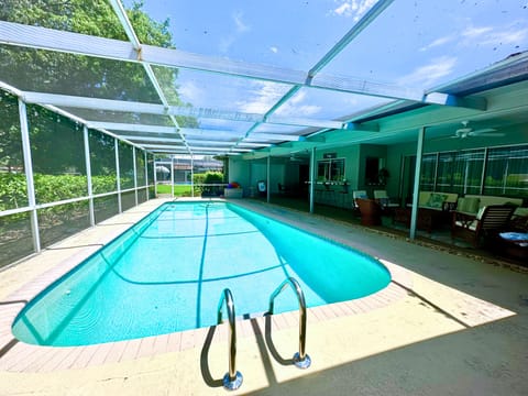 Our spacious screened-in pool with a view of the golf course view.