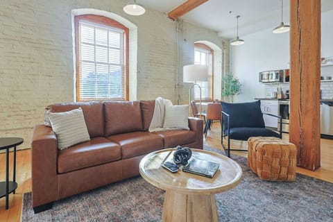 Living Room Retreat: Sunlight dances through tall windows, illuminating stylish decor and rich textures.