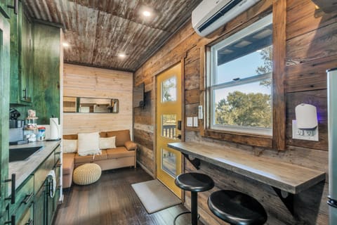 Step inside the cozy container, where compact design meets comfort. The space is thoughtfully arranged with clever storage solutions, a comfortable bed, and modern amenities, creating a warm and inviting atmosphere in a unique setting.