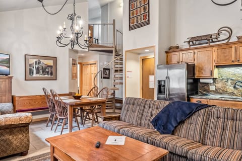 Main Living Space: Open layout, kitchen, living room and dining room, floor-to-ceiling stone mantle, ample natural light