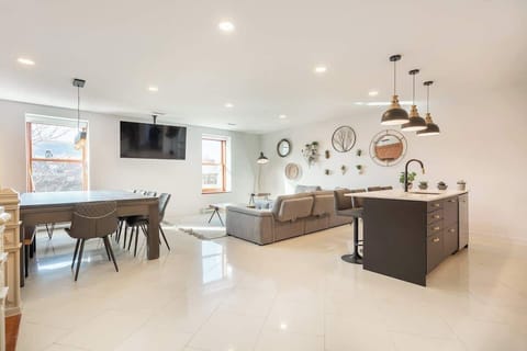 Spacious open-concept living area featuring a cozy lounge, elegant dining space, and modern kitchen — perfect for relaxing or entertaining.