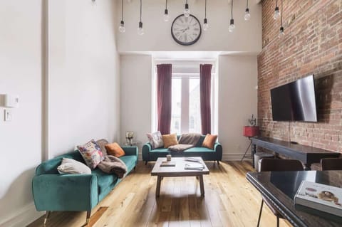 Bright and spacious living area featuring a stylish blend of brick and white tones, complemented by vinyl flooring for a warm, modern touch.