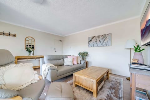 Relax on our grey couch, gather around the wooden lounge table, and enjoy your favourite shows on TV.