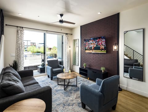 Unit 1 - 1st Floor: Warm and inviting living room featuring a Smart TV for entertainment, and designer furnishings including a sleeper sofa that converts into a Queen Bed.