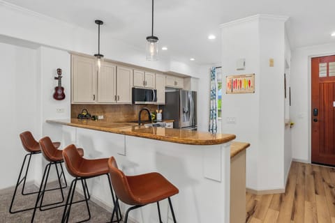 Full kitchen with breakfast bar, granite counters, and stainless steel appliances