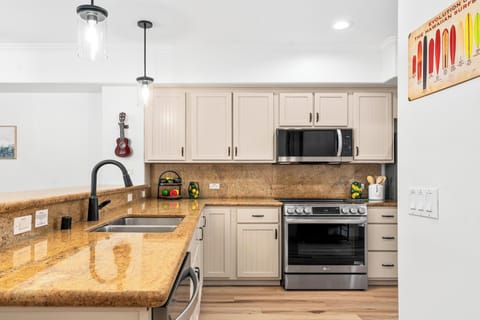Full kitchen with breakfast bar, granite counters, and stainless steel appliances