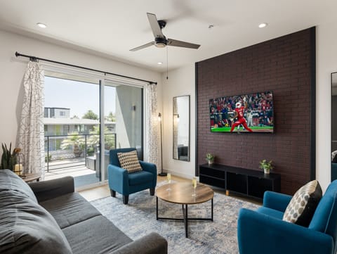 1st Floor: Warm and inviting living room featuring a Smart TV for entertainment, and designer furnishings including a sleeper sofa that converts into a Queen Bed.