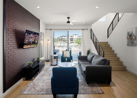 1st Floor: Warm and inviting living room featuring a Smart TV for entertainment, and designer furnishings including a sleeper sofa that converts into a Queen Bed.