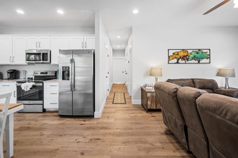 Open living space with full kitchen, dining, and seating all connected—designed so everyone can gather comfortably without feeling cramped. Clean, modern layout makes meals, movie nights, and group time easy and relaxed.