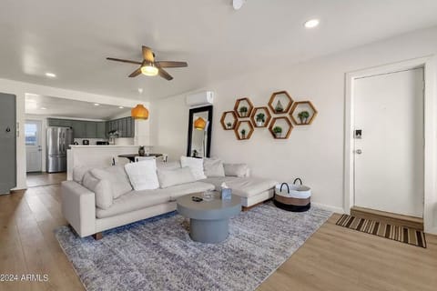 The living room features a comfy couch, coffee table, 50" TV, and a fireplace