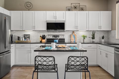 Featuring high-end stainless appliances and a central counter with seating