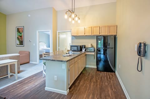 Partial kitchen includes refrigerator, microwave, and toaster oven