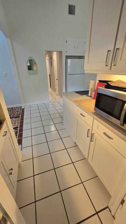 Hallway into bedrooms, living room on the right dining area on left
