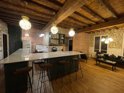 Spacious open kitchen and seating area with exposed brick walls in an authentic Art Deco apartment in Brussels city center.