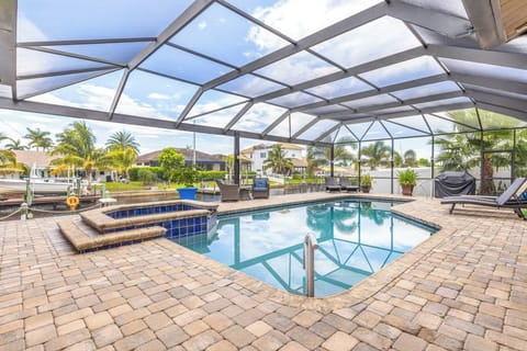 This backyard is the epitome of indoor/outdoor living at its finest with a covered swimming pool, lush green grass, and waterfront living with access to the canal!