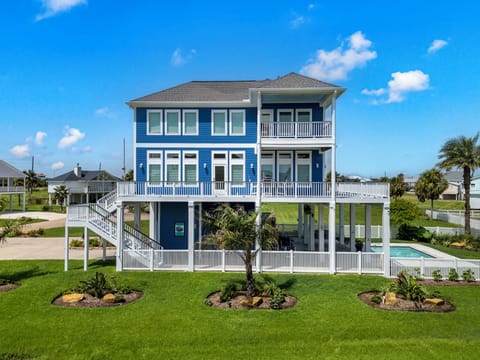 Stunning blue façade with spacious decks and lush tropical landscaping awaits