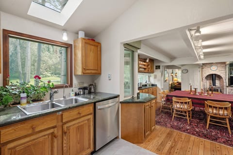 The main level of the home has a spacious kitchen, dining area with woodburning stove, laundry room and a full living room with wood fireplace.