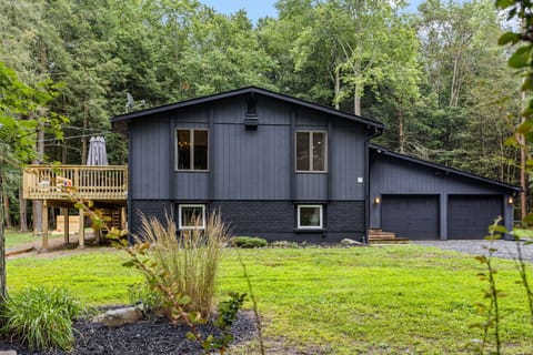 Chic & Cozy Forest Home – A beautifully designed modern cabin with dark exterior tones, large windows, and a peaceful setting perfect for relaxation.