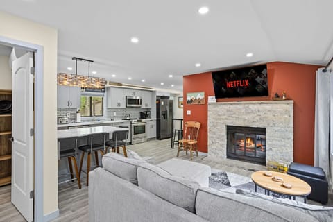 Sink into the plush sectional and unwind by the warm glow of the fireplace. With an open-concept design, modern kitchen, and a big-screen TV for endless entertainment, this space is perfect for both relaxation and socializing.