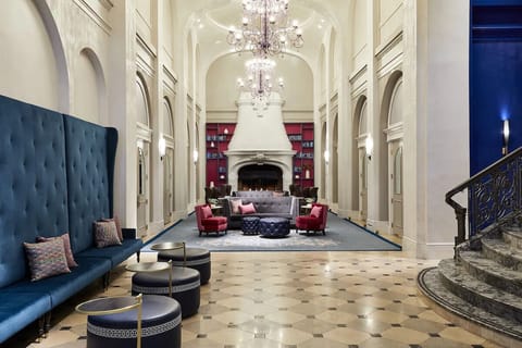 Step into a grand lobby beneath sparkling chandeliers and arches.
