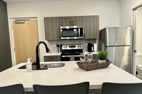 Modern kitchen with stainless steel appliances, spacious island, and stylish touches-perfect for entertaining!