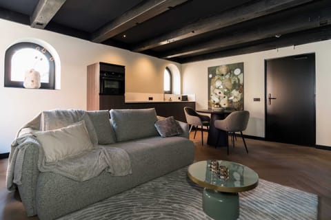 Living room space with comfortable sofa, and kitchen with dining area