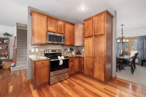 Your fully-equipped kitchen welcomes you with warm wood cabinets, granite counters, and modern stainless appliances for memorable home-cooked meals together.