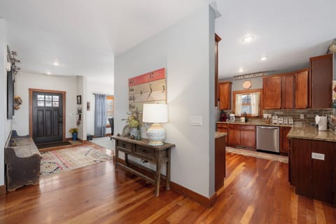 Step into this welcoming open-concept space where warm hardwood floors flow seamlessly from your entryway into the fully equipped kitchen, perfect for home-cooked meals.