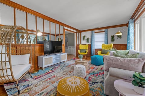 Main living room with cozy egg chair and TV