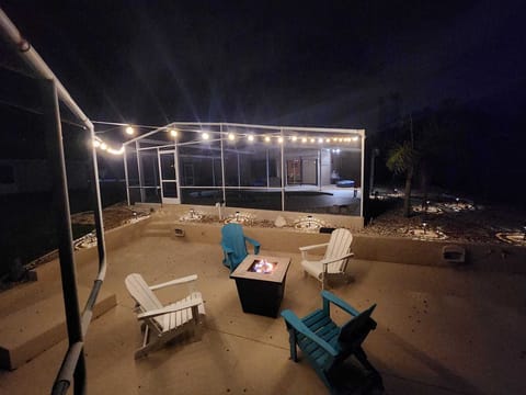 Outdoor seating area with fire pit and evening lighting.