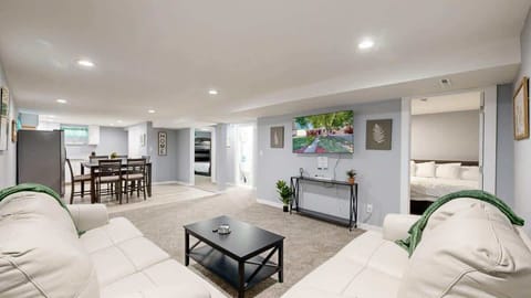 Relax and enjoy a movie in the living room, featuring a comfortable seating area and a cozy ambiance for the perfect entertainment experience.