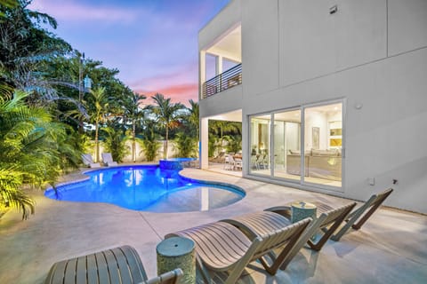 Pool & patio with chaise lounges and home at twilight