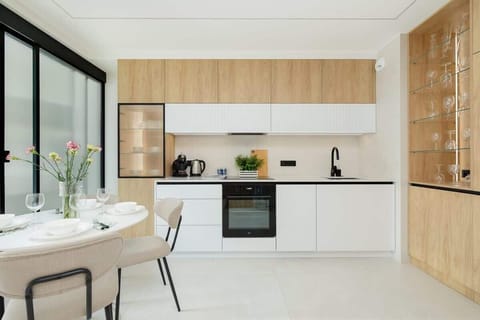 A small but sleek kitchen area with wood and white finishes. Functional and stylish for everyday cooking.