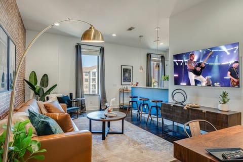 Unit 1: Bright and open living area with designer furnishings and smart TV.
