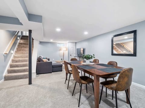 Enjoy meals at the dining table set beside the stairs in a bright, open gathering space