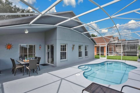 Covered patio with outdoor dining area and screened pool for relaxing gatherings