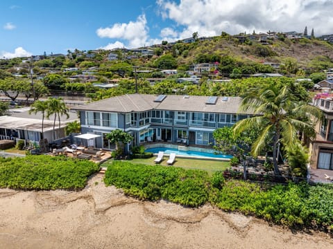 Oceanfront façade of Wailupe Beachfront Getaway with pool, deck, and direct sandy beach access